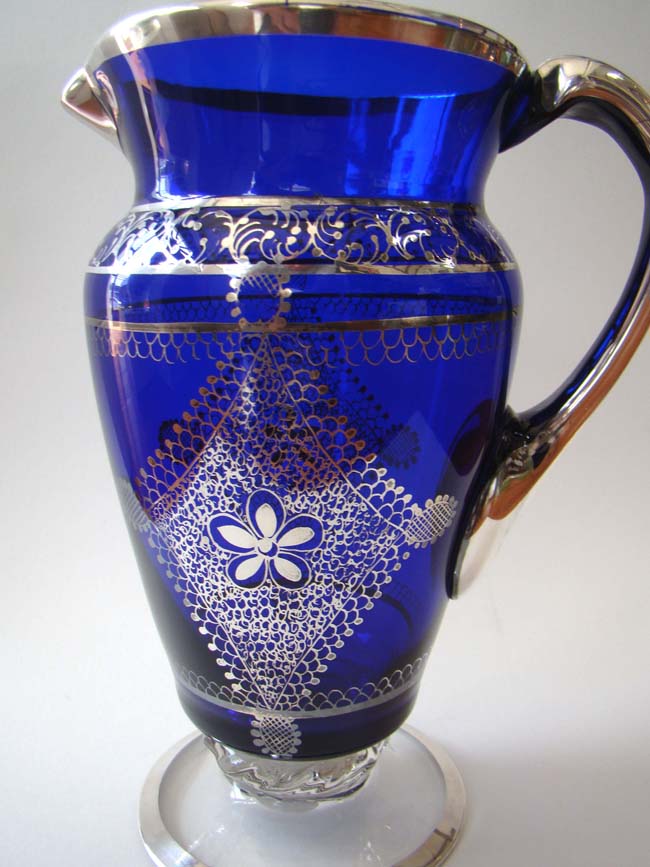 A magnificent antique cobalt blue glass pitcher with intricate silver overlay circa 1900